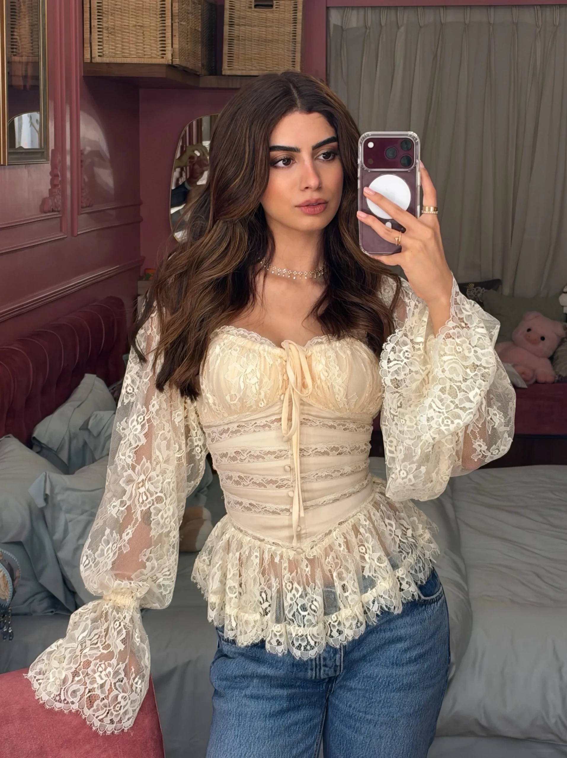 Woman styled in a white lace top with dark bottoms for a sharp contrast look.