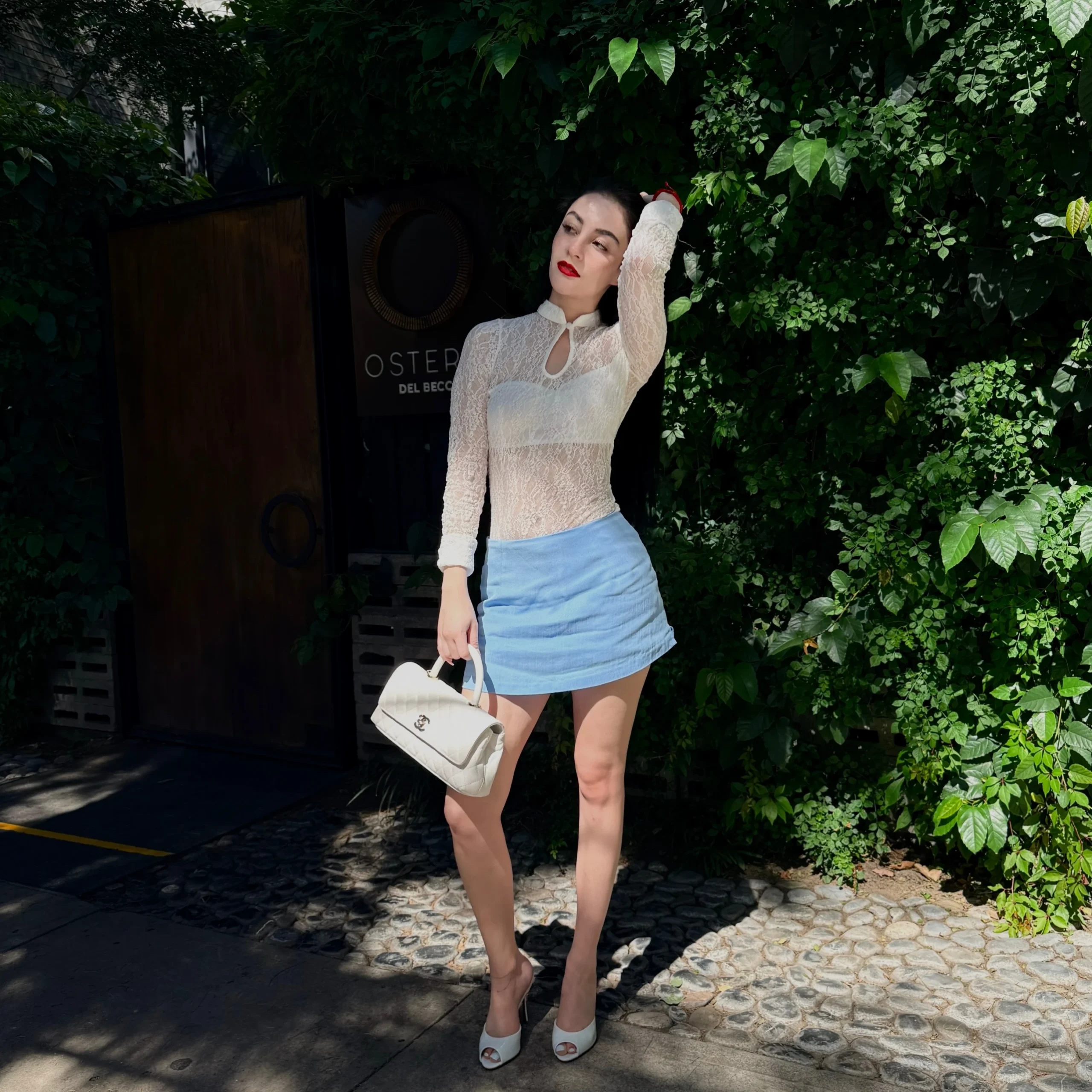 Woman wearing a white lace top as the focal point of her outfit.