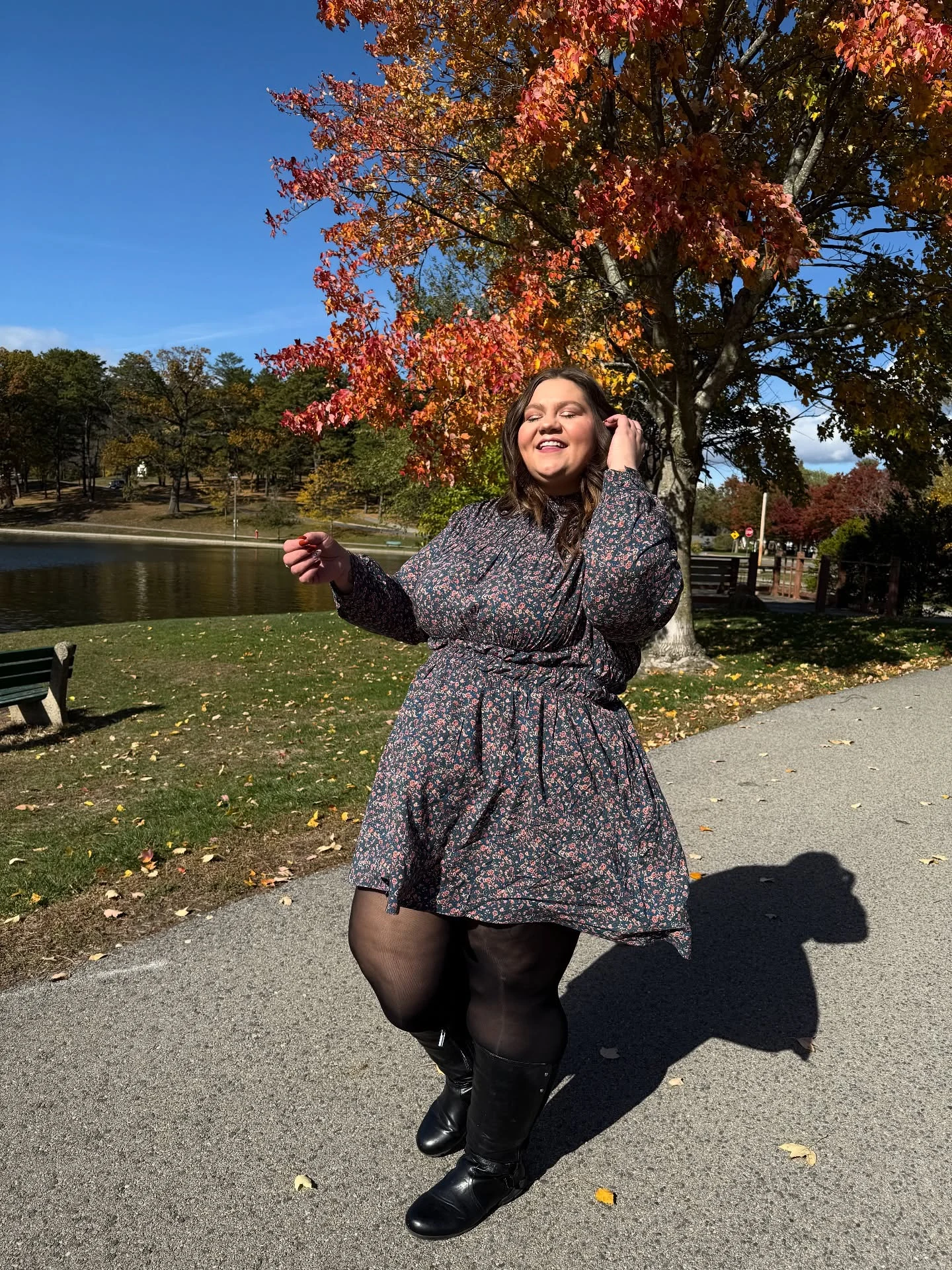 Dark blue floral mini dress with cinched waist, sheer black tights, and black knee-high boots.
