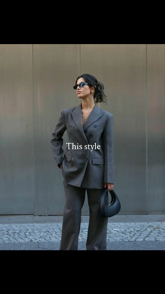 Woman styled in a brown herringbone blazer, black turtleneck, and black trousers.