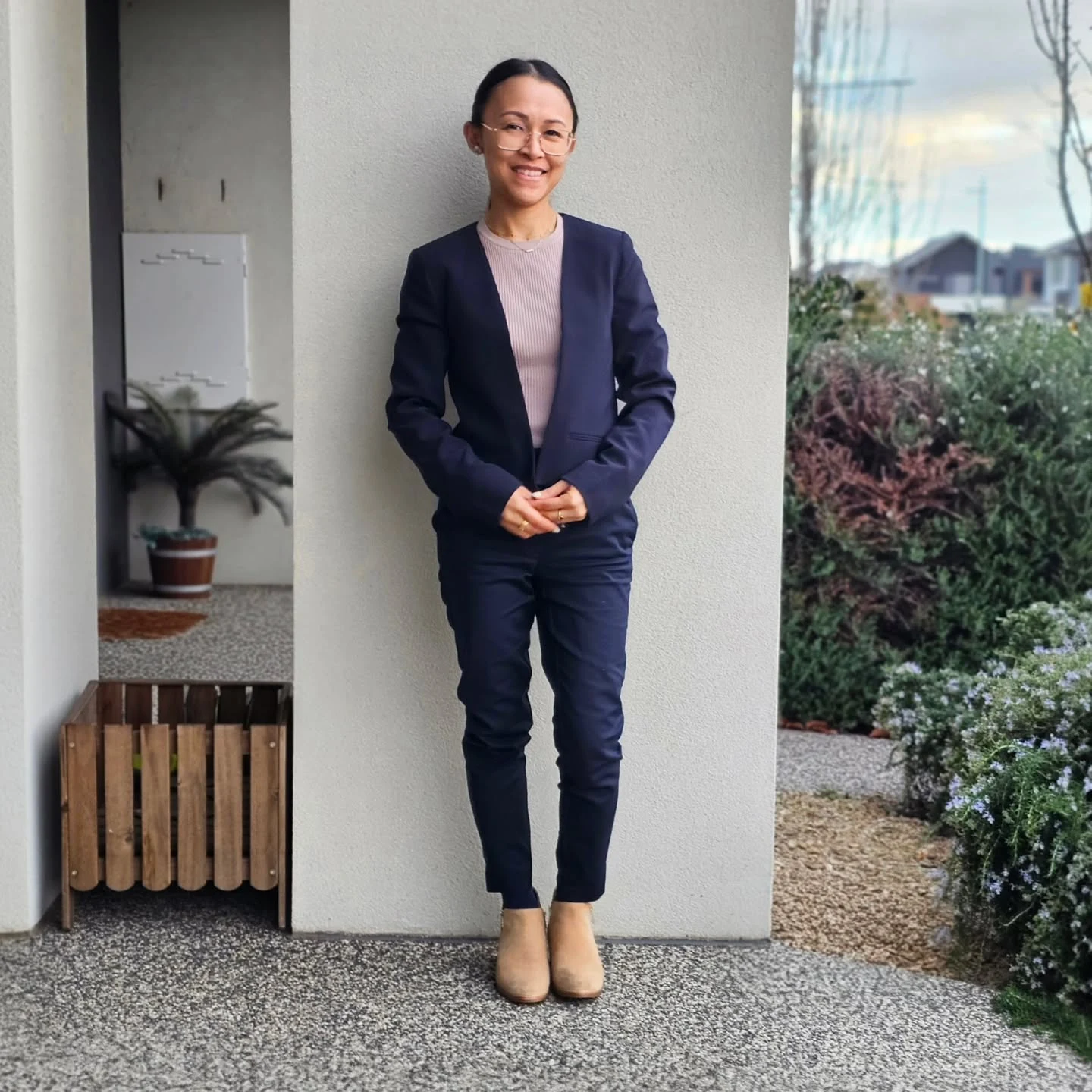 navy blue blazer and matching trousers over light pink ribbed knit top, tan suede ankle boots