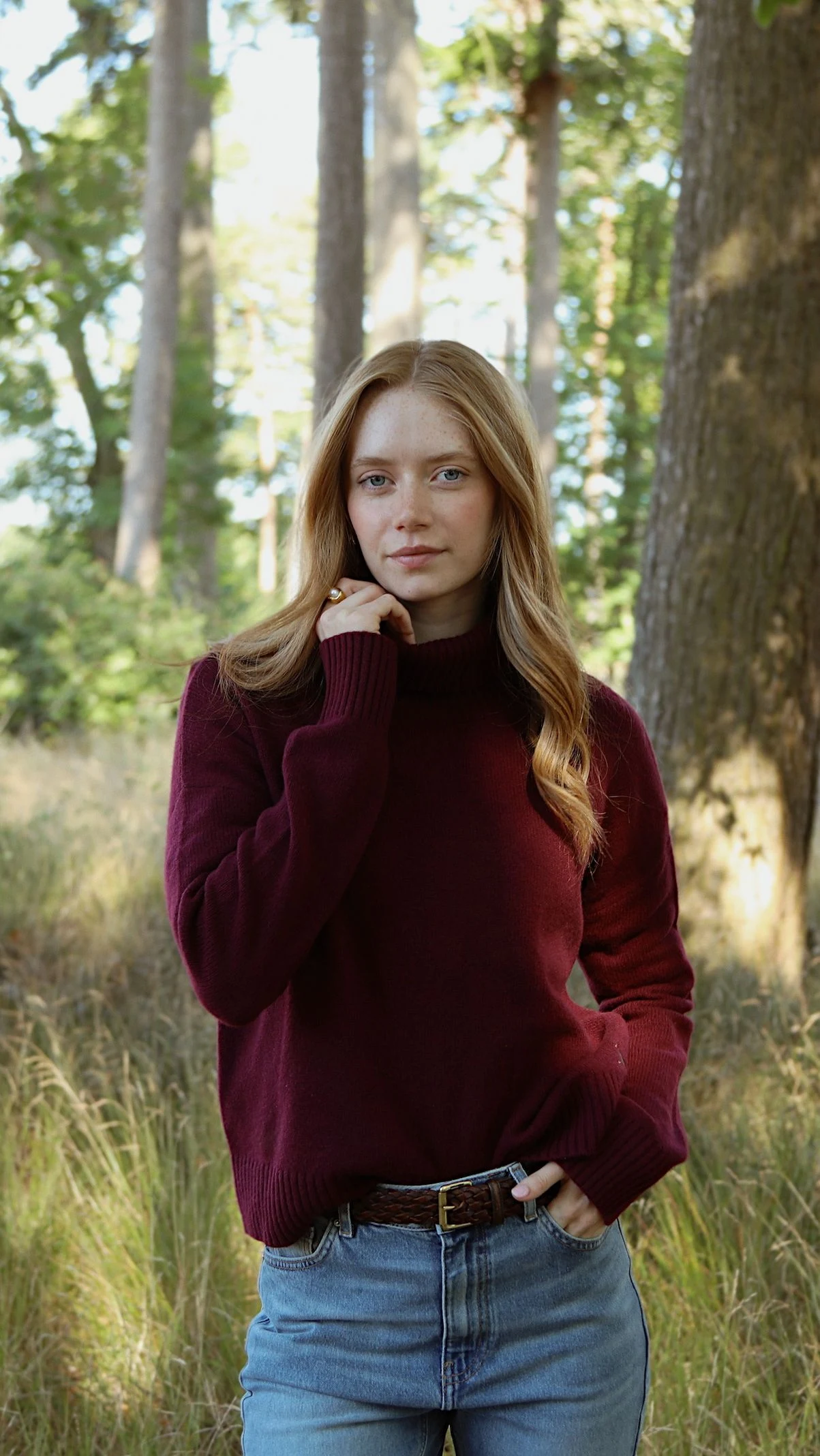 Plum turtleneck sweater, light-wash straight-leg jeans, brown braided leather belt
