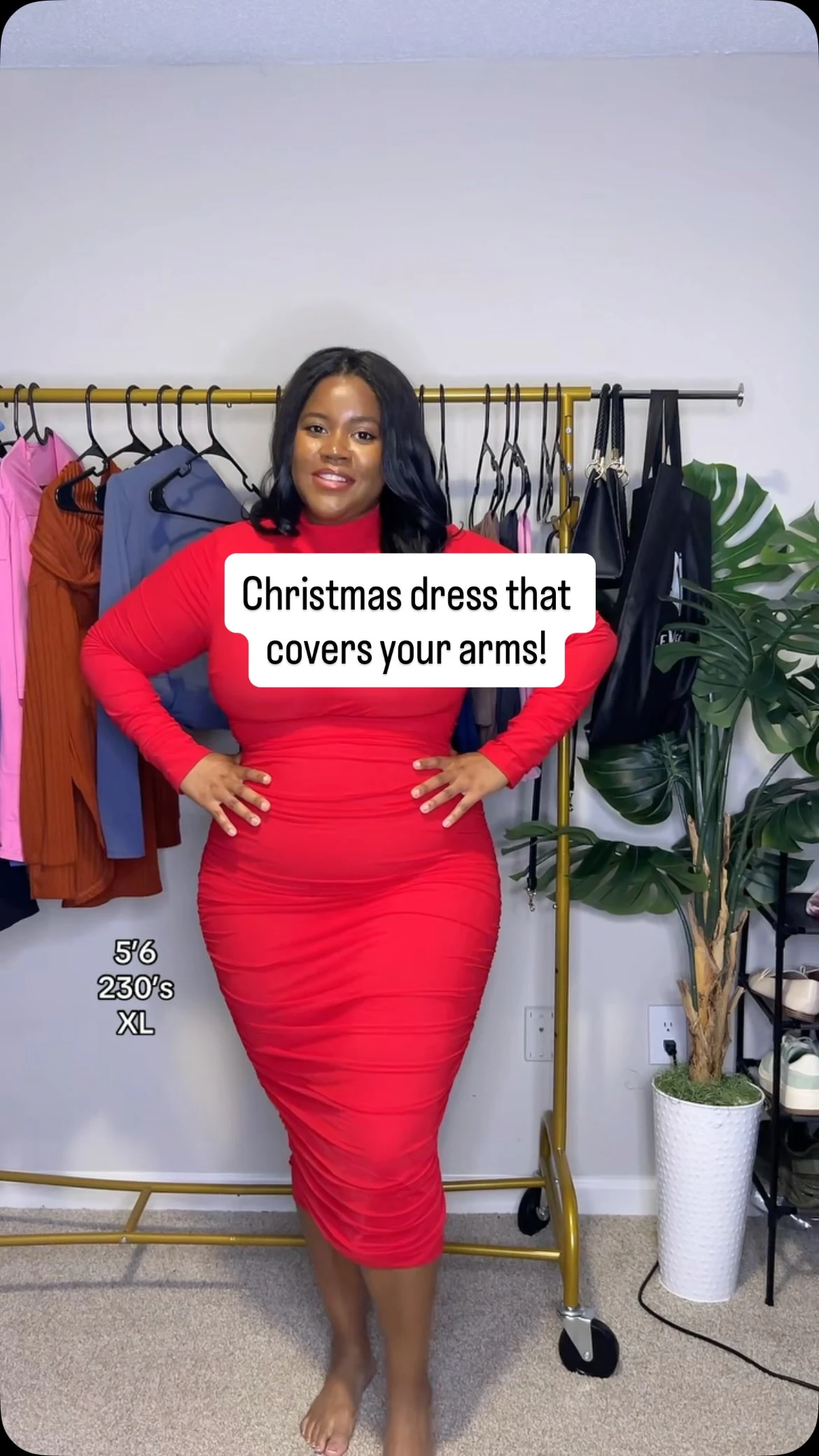 Bright red fitted ruched midi dress with high neckline and long sleeves, worn barefoot indoors.
