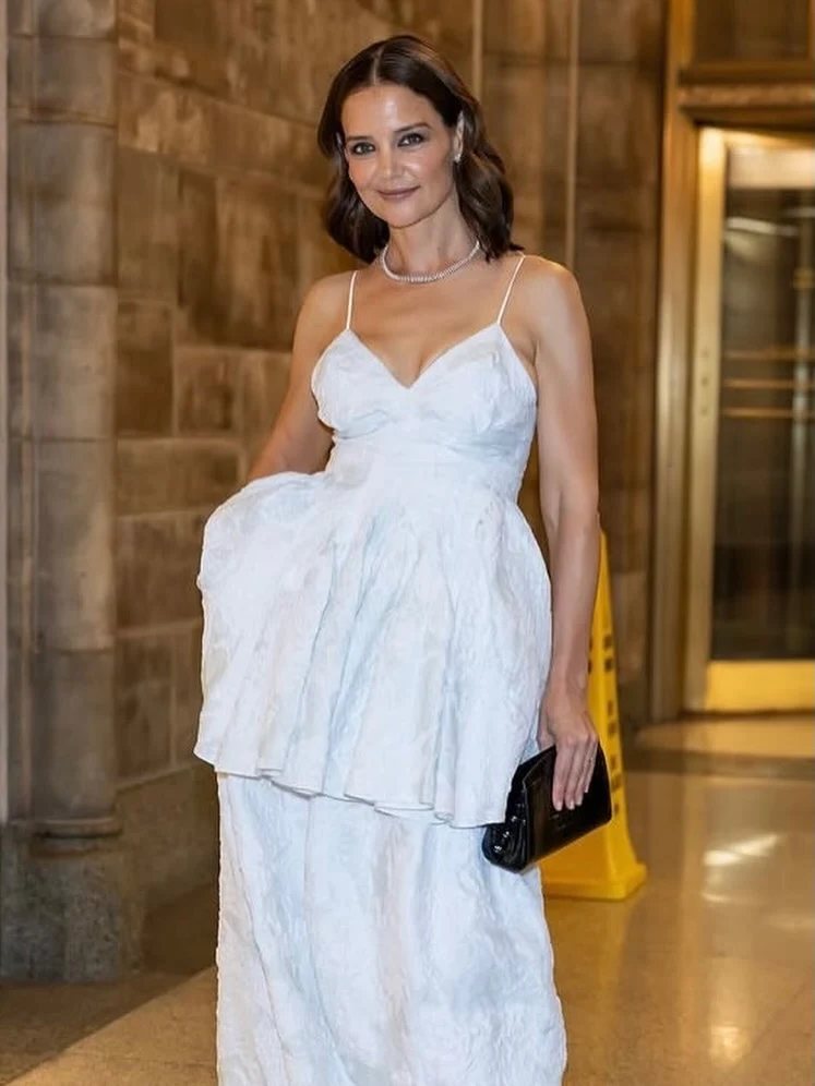 Floor-length white textured gown with spaghetti straps and a sweetheart V-neckline.