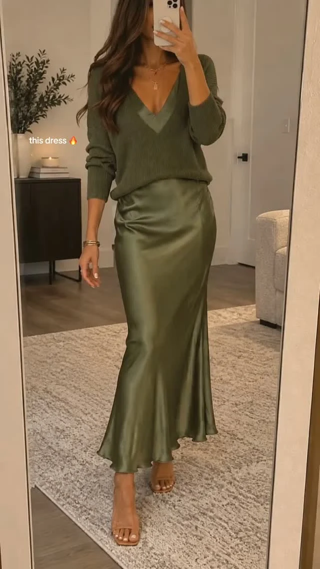 Olive V-neck sweater paired with a matching gathered satin skirt and tan open-toe heeled sandals.