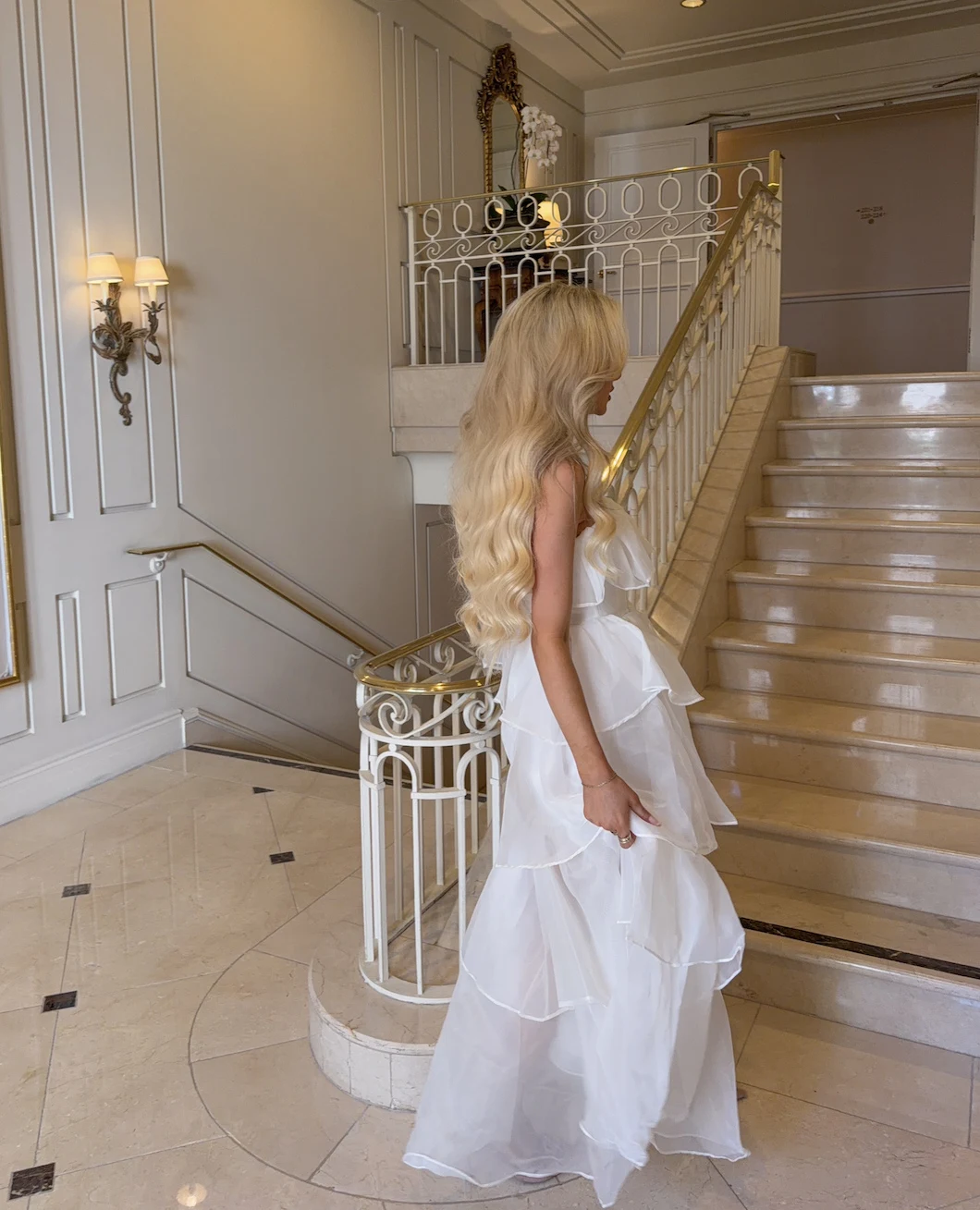 White chiffon maxi dress with layered ruffles and delicate rosette drape details.
