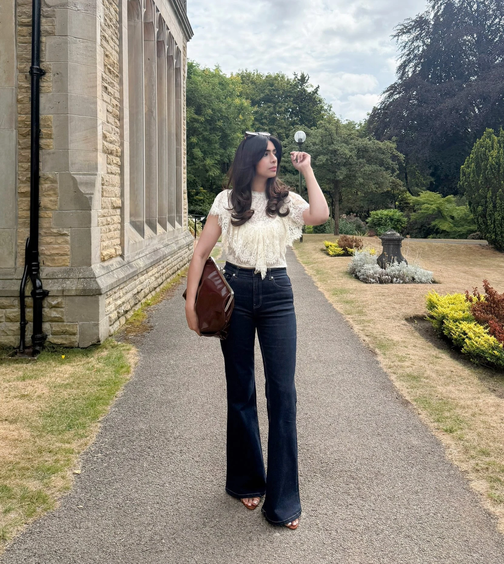 Woman wearing a white floral lace blouse with sleek black pants for a polished look.