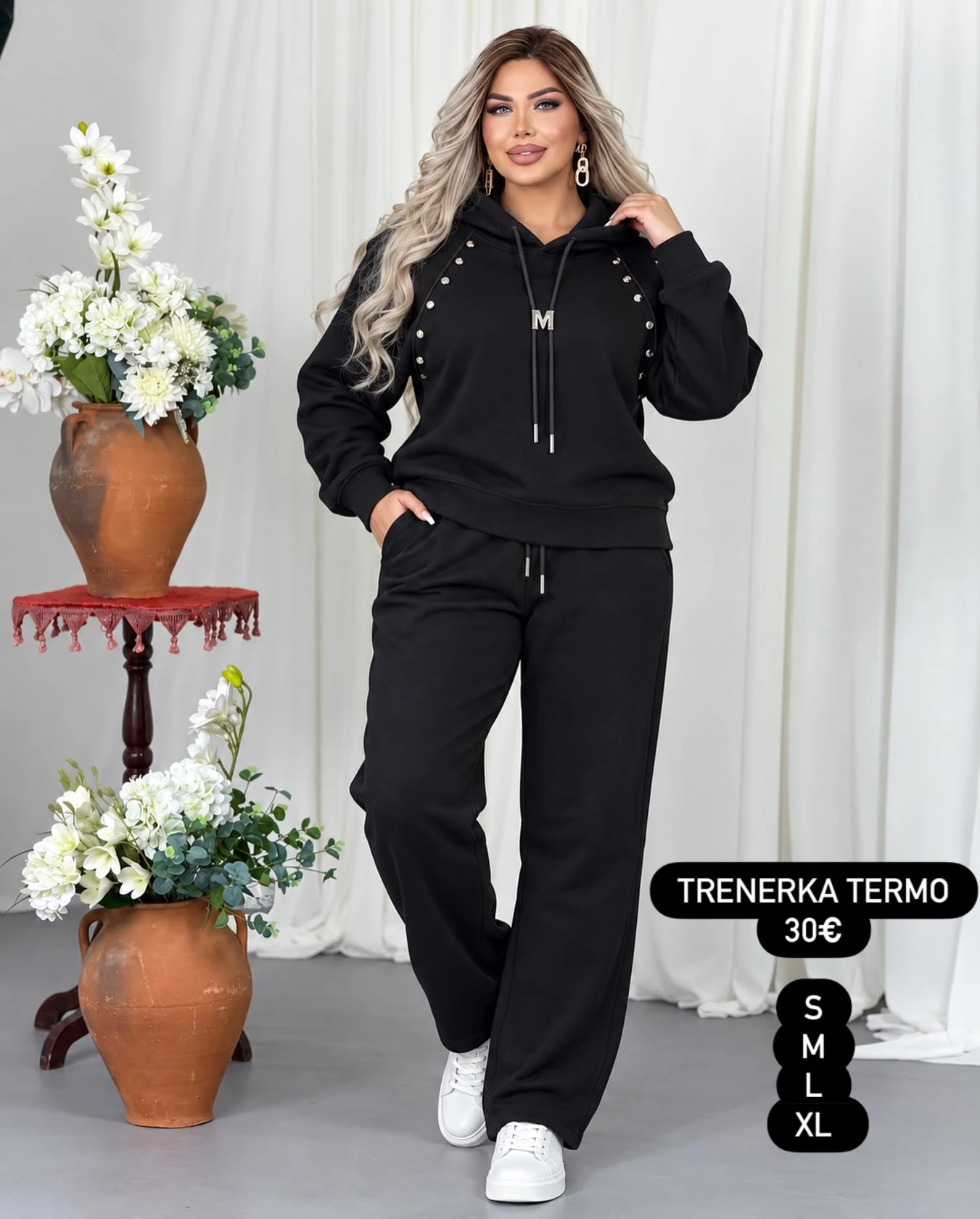 Black studded hoodie and matching sweatpants paired with white low-top sneakers.