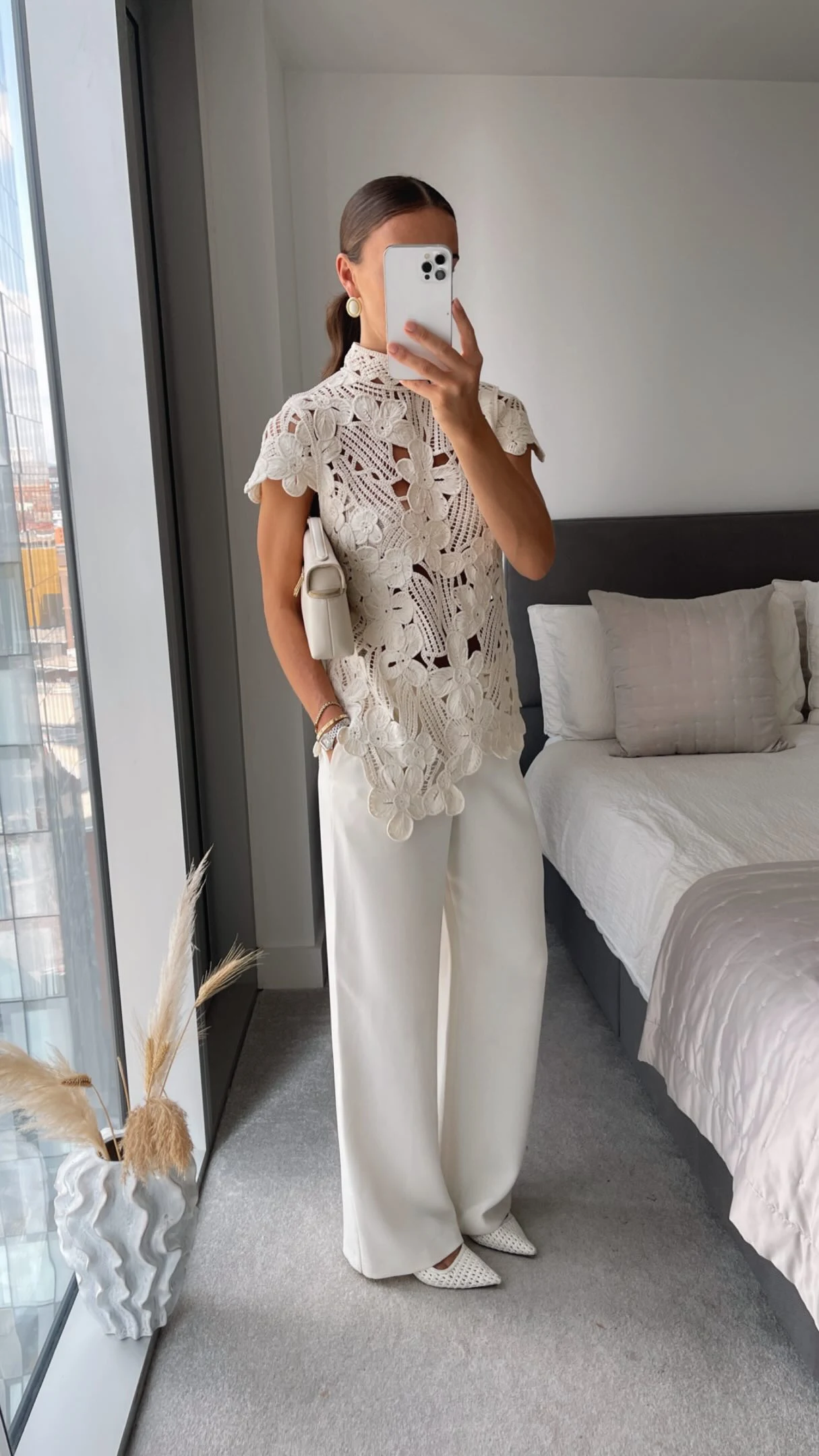 Cream crochet lace top styled with black flared trousers and various white and blue bottom options.