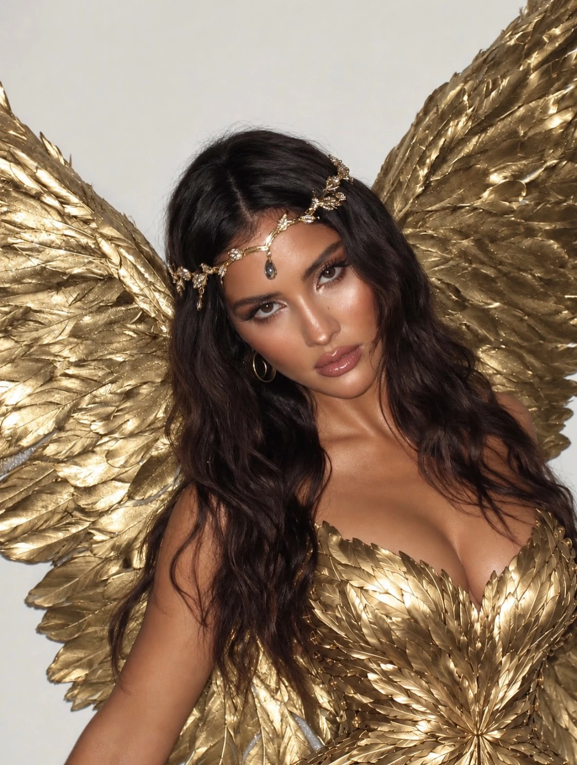 Large metallic gold wings, strapless bodice made from feather-shaped panels, gold crystal headpiece