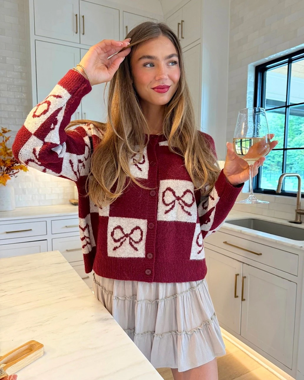 Burgundy cropped cardigan with cream patterned panels paired with a pale gathered tiered mini skirt.